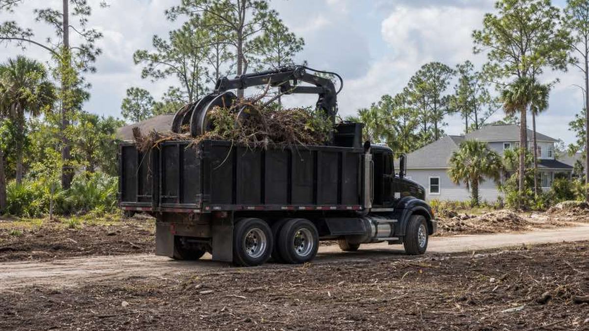 AI-generated image of grapple truck positioned beside consolidated piles of cut branches and logs on a Bunnell land-clearing site before grading