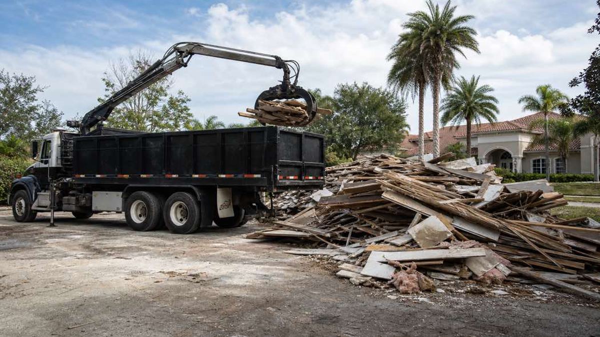 AI-generated image of separated piles of wood, concrete, roofing, and drywall at a Daytona Beach construction site with clear truck access